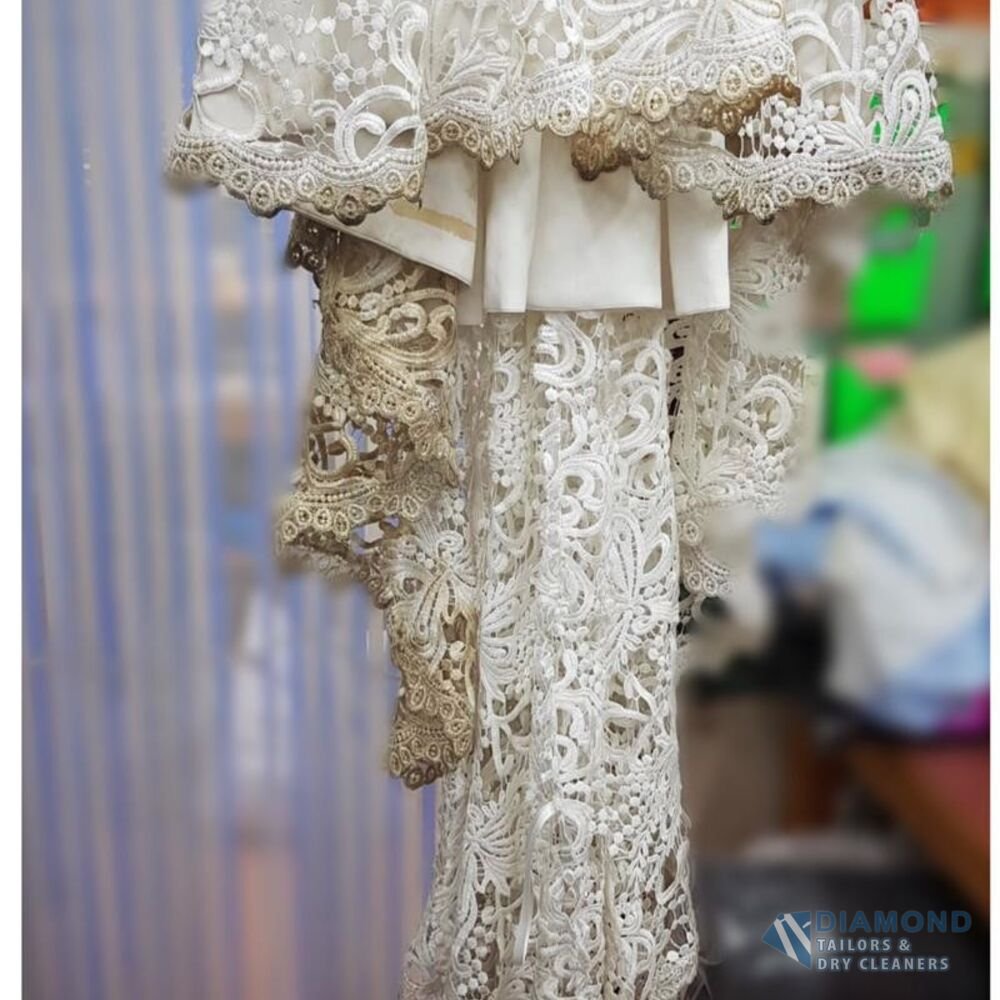 Guipure lace wedding dress hem before cleaning — the lace is dulled and yellow-grey